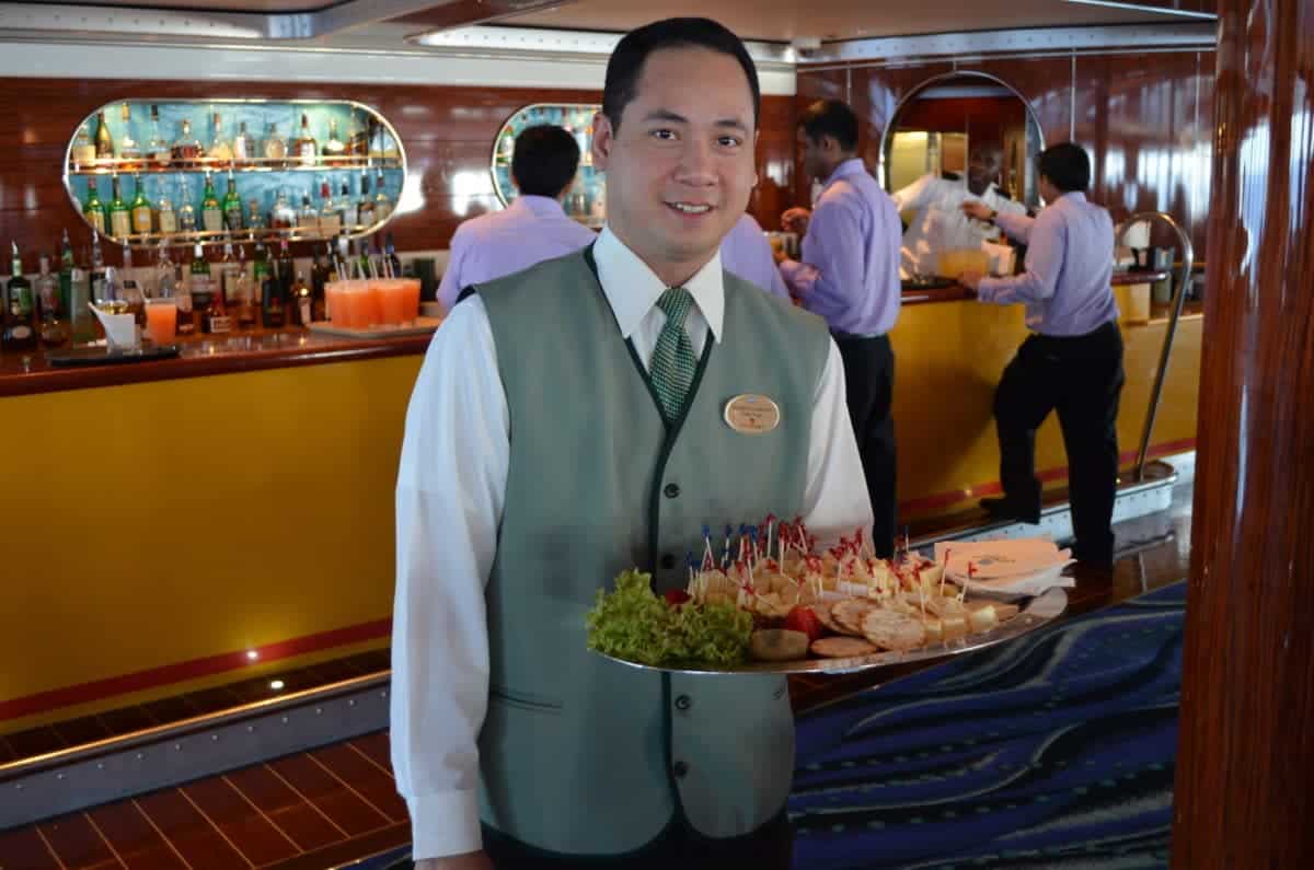 Waiter aboard Norwegian Jade serves hot and cold appetizers at the bar.