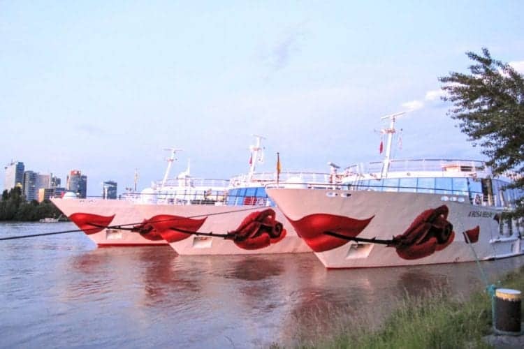 A Rosa river cruise ship docked alongside the river.