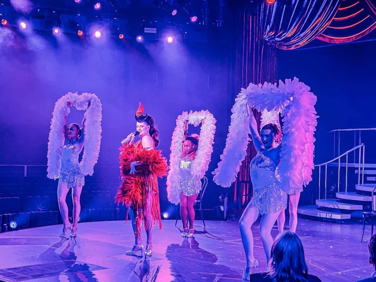 Performers on stage aboard Holland America Nieuw Statendam with feather boas.