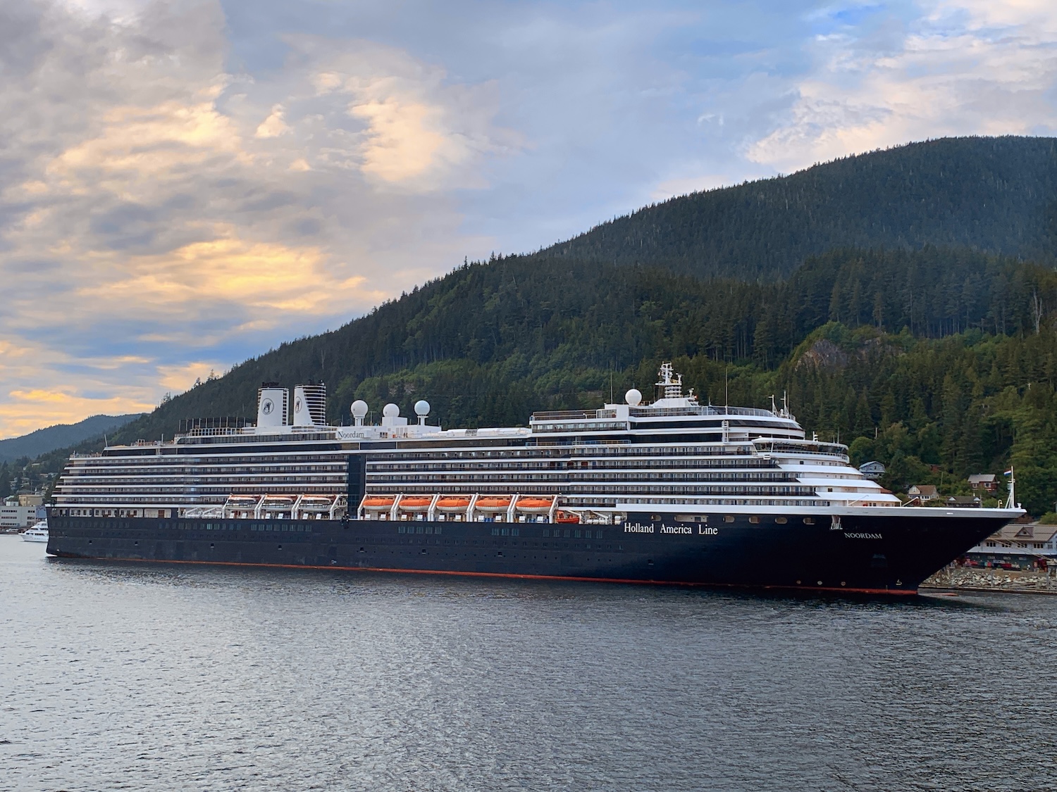 Holland America Noordam docked in Alaska at sunset with mountains in the background